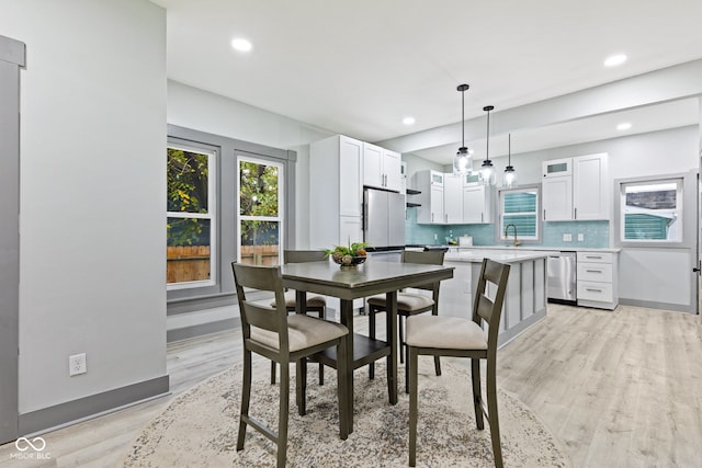 dining room featuring sink and light wood-type flooring