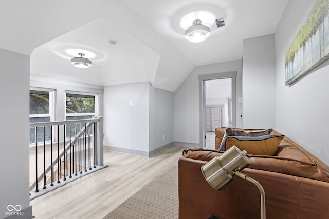 living room with light wood-type flooring and vaulted ceiling