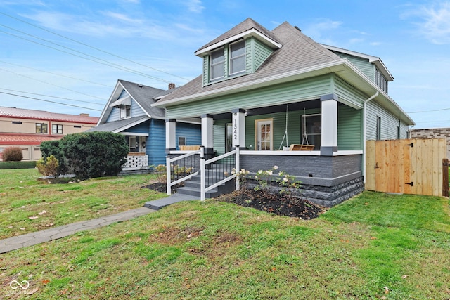 bungalow featuring covered porch and a front lawn