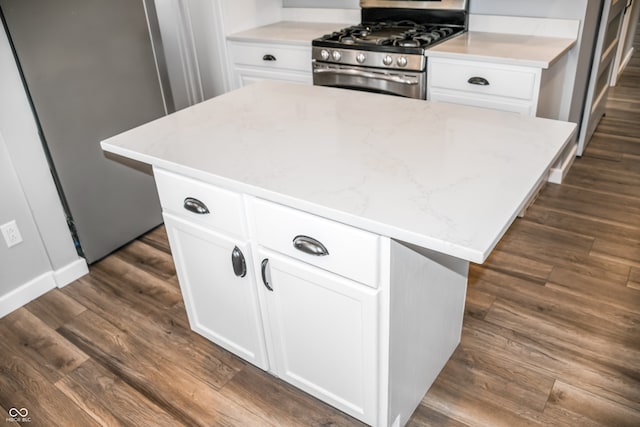 kitchen featuring white cabinets, a kitchen island, dark hardwood / wood-style flooring, and stainless steel gas range