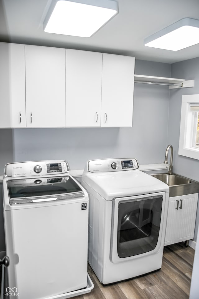 laundry area featuring dark hardwood / wood-style floors, cabinets, separate washer and dryer, and sink