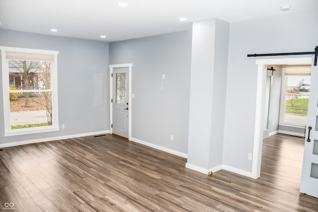 empty room with hardwood / wood-style floors and a barn door