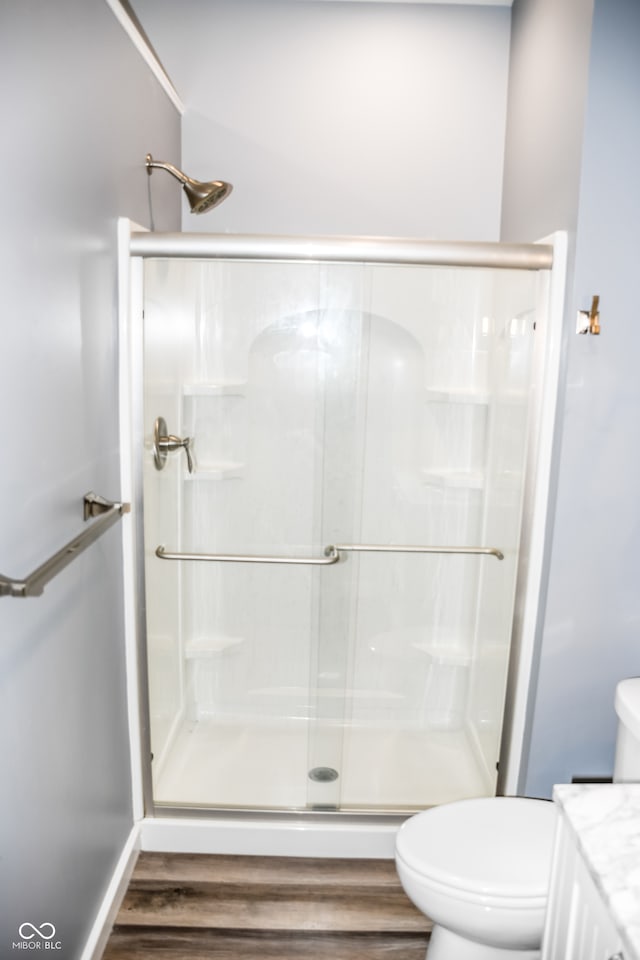 bathroom featuring vanity, hardwood / wood-style flooring, toilet, and an enclosed shower