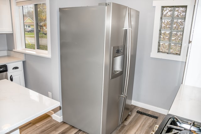 kitchen featuring white cabinets, light hardwood / wood-style floors, and appliances with stainless steel finishes