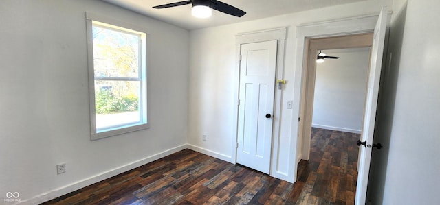 unfurnished bedroom with ceiling fan and dark wood-type flooring