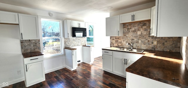 kitchen featuring dark hardwood / wood-style flooring, backsplash, a wealth of natural light, and sink