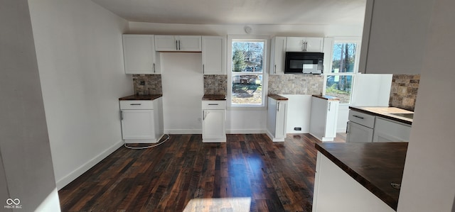 kitchen with dark hardwood / wood-style floors, white cabinetry, and backsplash