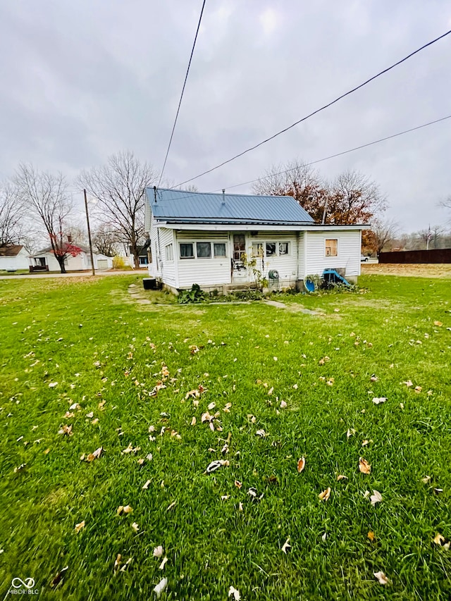 rear view of house featuring a yard