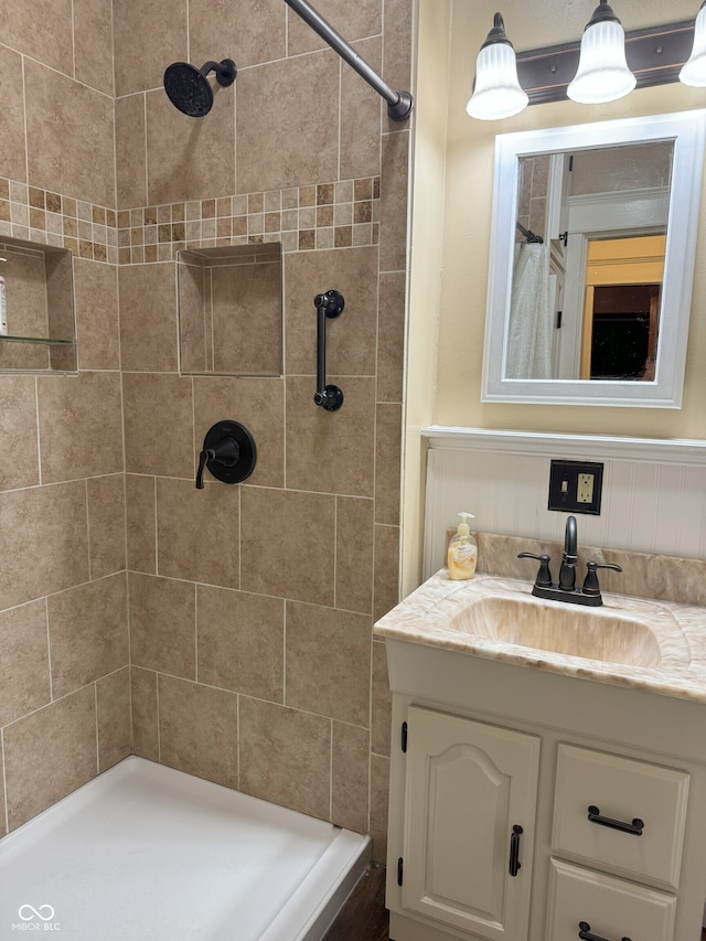 bathroom featuring tiled shower and vanity