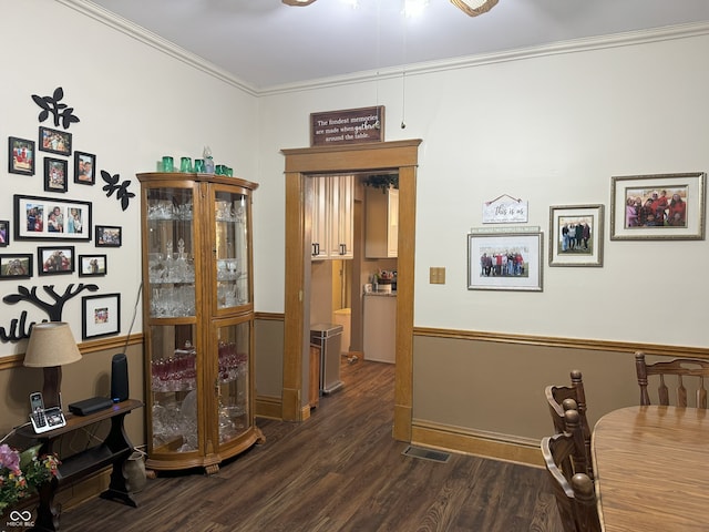 dining space with crown molding and dark wood-type flooring