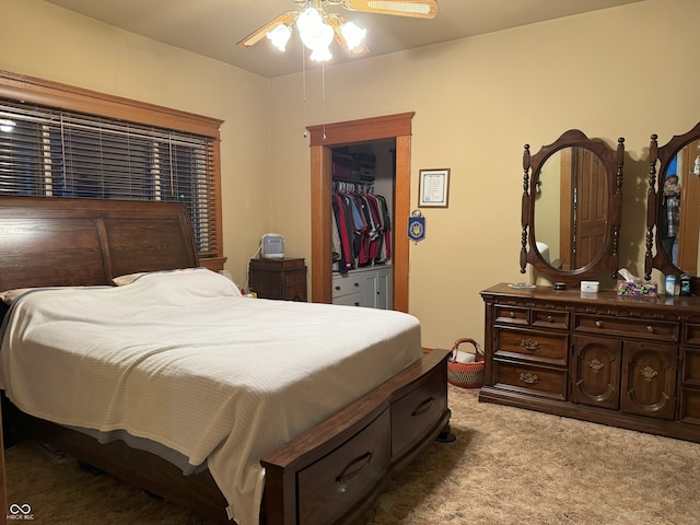 bedroom with ceiling fan, a walk in closet, light carpet, and a closet