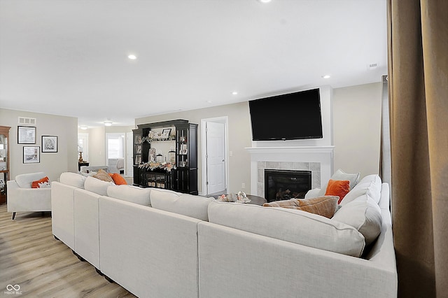 living room with light wood-type flooring and a fireplace