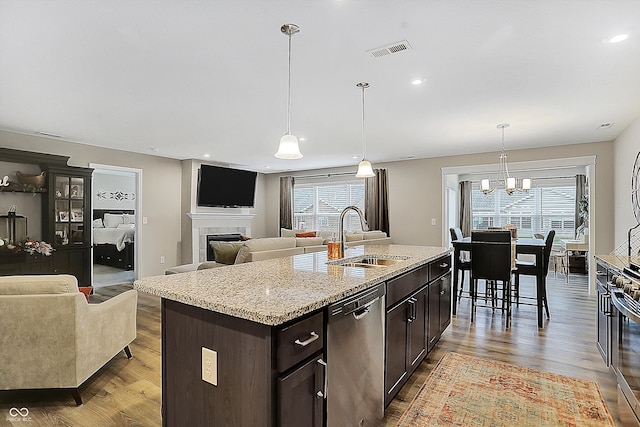 kitchen with a wealth of natural light, light wood-type flooring, an island with sink, and appliances with stainless steel finishes