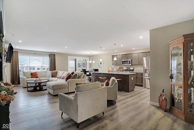 living room featuring light hardwood / wood-style floors and an inviting chandelier