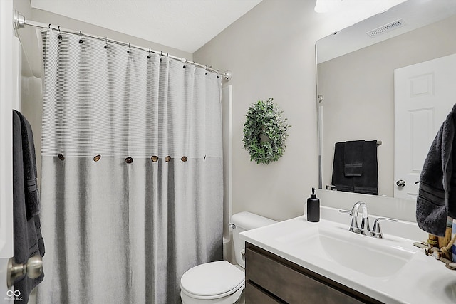 bathroom with a textured ceiling, vanity, and toilet