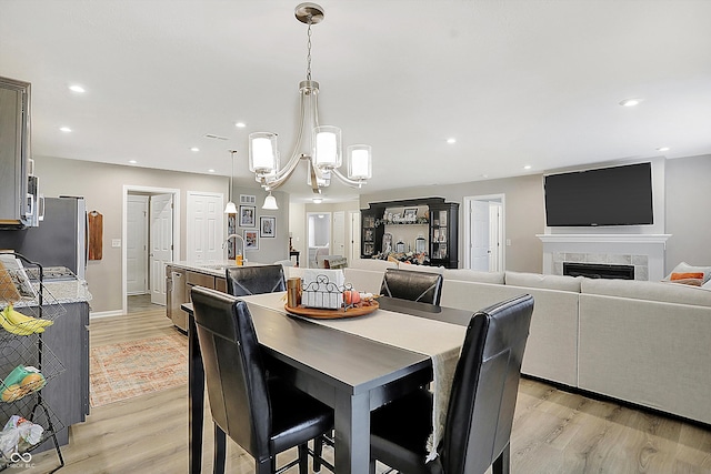 dining room featuring light hardwood / wood-style floors, a notable chandelier, and sink