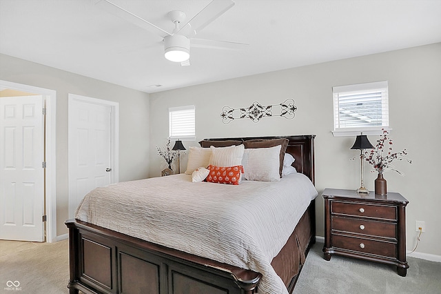 bedroom featuring light colored carpet, multiple windows, and ceiling fan