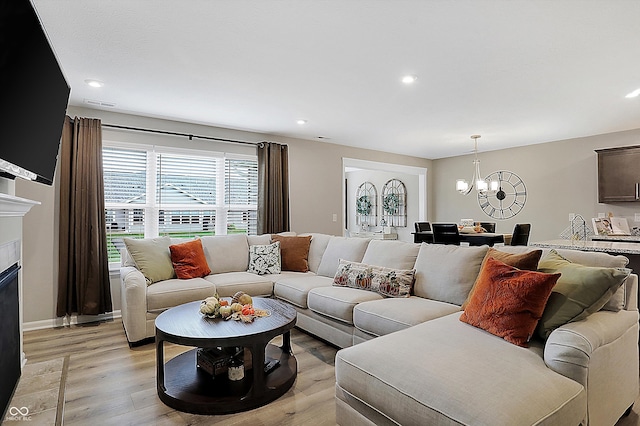 living room with light hardwood / wood-style flooring and an inviting chandelier