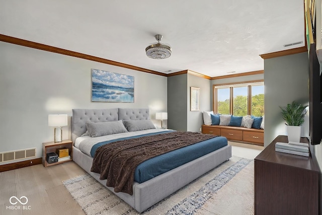 bedroom with crown molding and light hardwood / wood-style floors