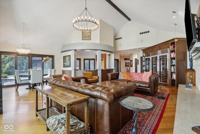 living room with light hardwood / wood-style flooring, high vaulted ceiling, a chandelier, and beamed ceiling