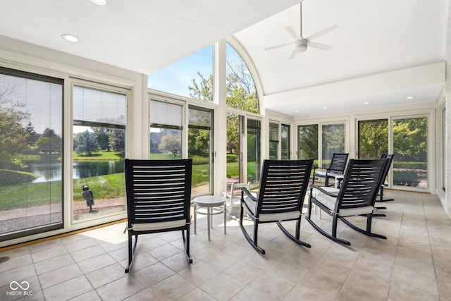 sunroom with ceiling fan, a water view, and vaulted ceiling