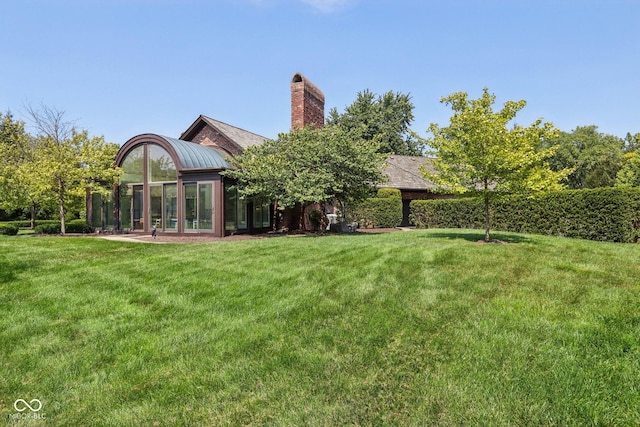 back of property featuring a sunroom and a yard