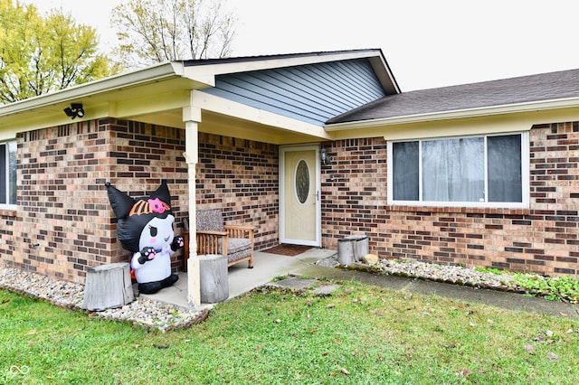 view of exterior entry with a lawn