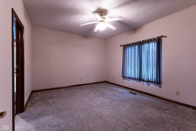 carpeted empty room with ceiling fan and a textured ceiling