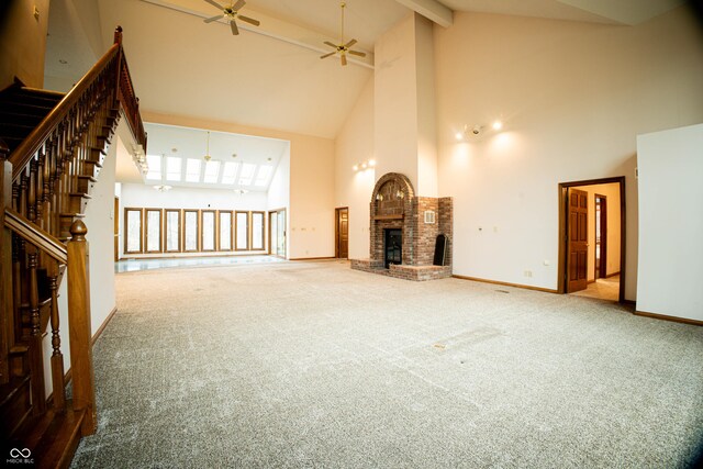 4257 Tattersall Dr, Plainfield, IN 46168 - unfurnished living room featuring high vaulted ceiling, a ceiling fan, a brick fireplace, beamed ceiling, and stairway