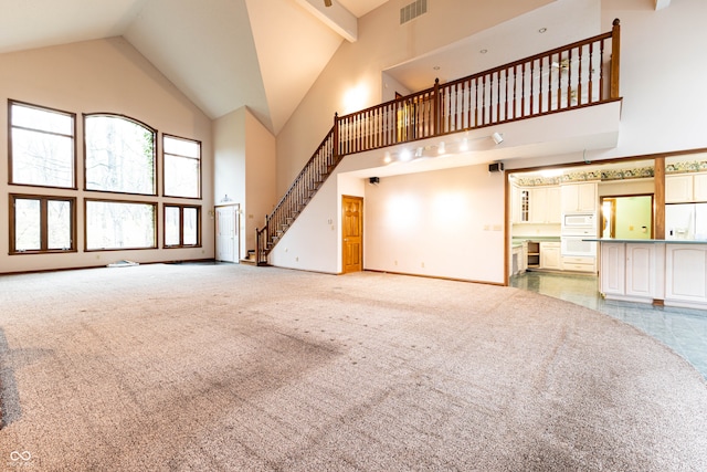 unfurnished living room with light carpet and high vaulted ceiling