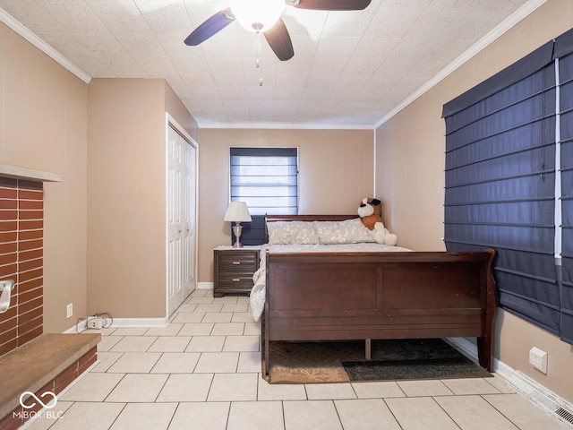 bedroom with ceiling fan, light tile patterned floors, crown molding, and a closet