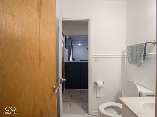 bathroom with toilet, vanity, and tile patterned floors