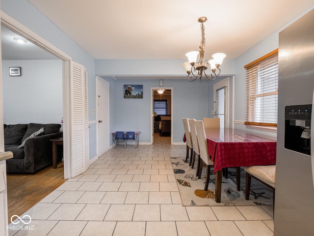 dining space featuring light hardwood / wood-style floors and an inviting chandelier