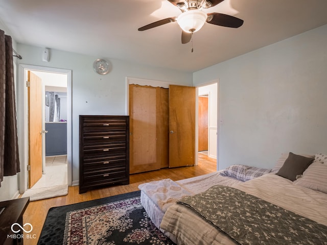 bedroom with ceiling fan, light hardwood / wood-style floors, and a closet