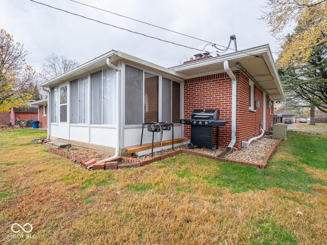 view of home's exterior featuring a sunroom and a yard