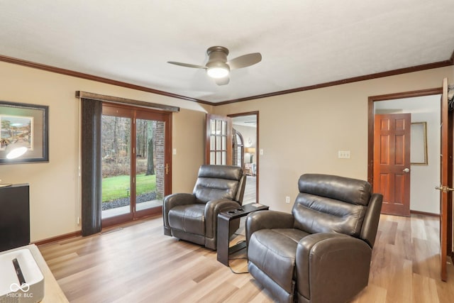 living area with light hardwood / wood-style floors, ceiling fan, and crown molding