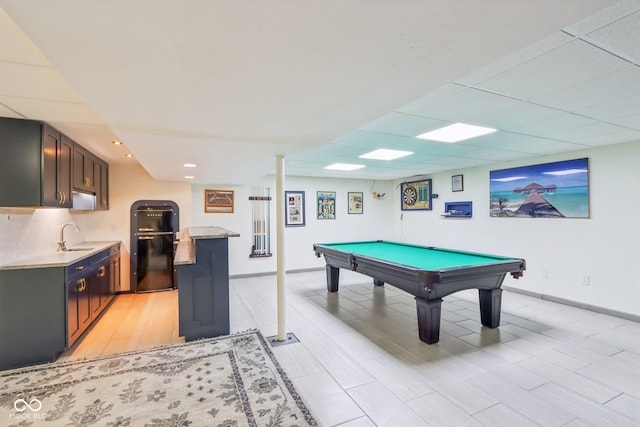 game room with a paneled ceiling, sink, light hardwood / wood-style flooring, and billiards