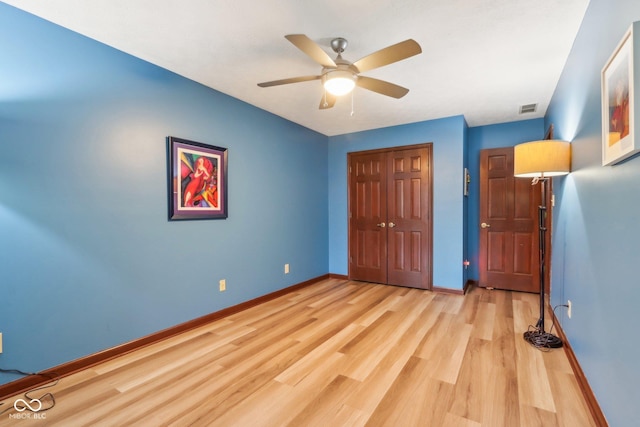 unfurnished bedroom with ceiling fan, light hardwood / wood-style floors, and a closet