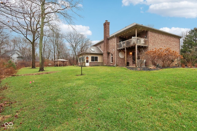 rear view of property with a yard and a balcony