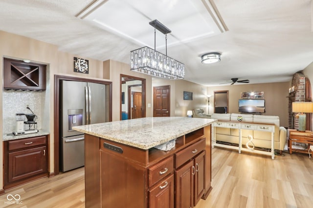 kitchen featuring light hardwood / wood-style flooring, ceiling fan, decorative light fixtures, a kitchen island, and stainless steel fridge with ice dispenser