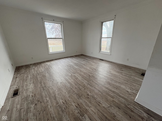 unfurnished room with hardwood / wood-style floors and plenty of natural light