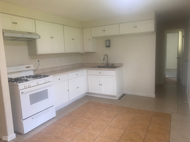 kitchen with sink, white cabinets, white range with gas stovetop, and light tile patterned floors