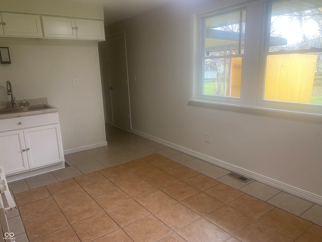 unfurnished dining area featuring light tile patterned flooring and sink