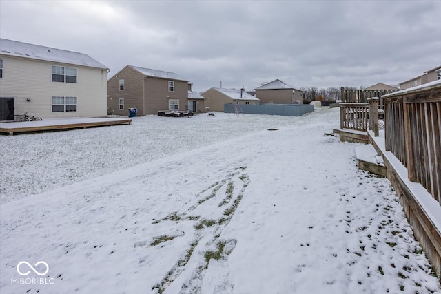 yard layered in snow with a wooden deck