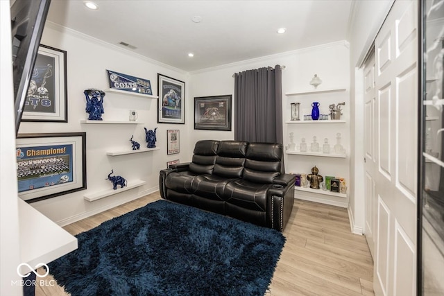 cinema room featuring light hardwood / wood-style flooring and ornamental molding