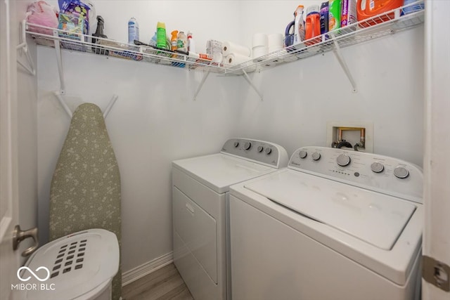 clothes washing area featuring washer and dryer and hardwood / wood-style floors