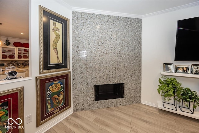 living room featuring a fireplace, hardwood / wood-style floors, tile walls, and ornamental molding