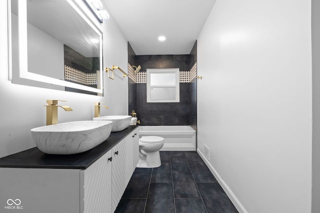 full bathroom featuring tile patterned flooring, vanity, tiled shower / bath combo, and toilet