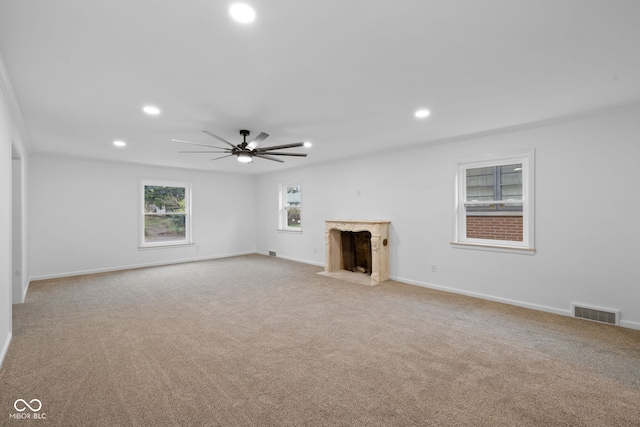 unfurnished living room featuring light carpet and a high end fireplace