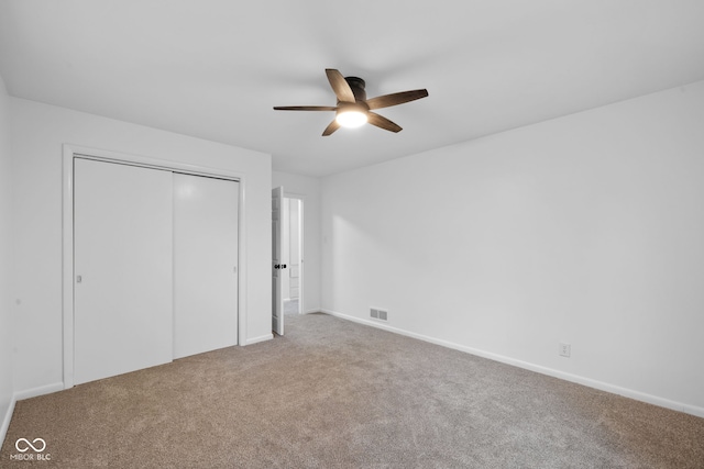 unfurnished bedroom featuring ceiling fan, carpet floors, and a closet